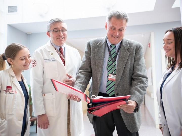 Dr. Brodeur and pharmacy students gather around to observe information at OLOM rotation